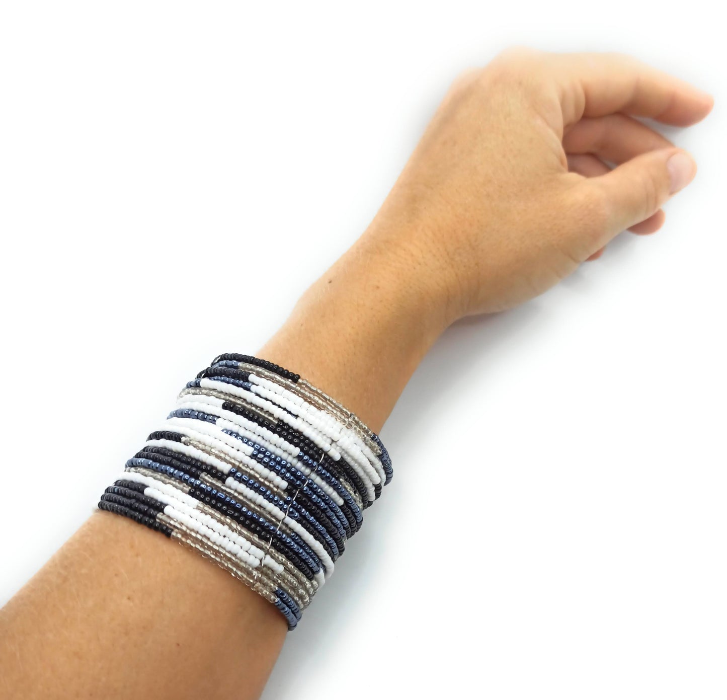 Brazalete artesanal de cuentas en espiral con alambre de metal, hecho a mano con diseño único y colorido.