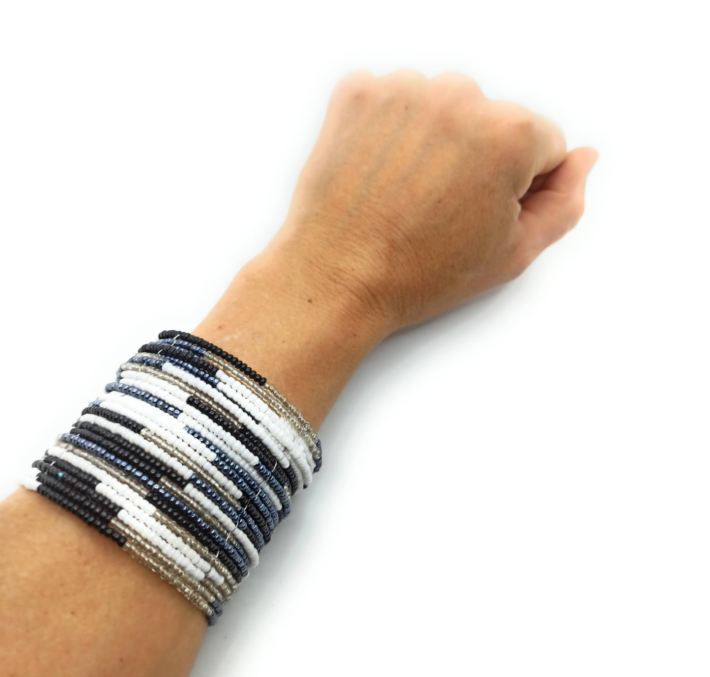 Brazalete artesanal de cuentas en espiral con alambre de metal, hecho a mano con diseño único y colorido.