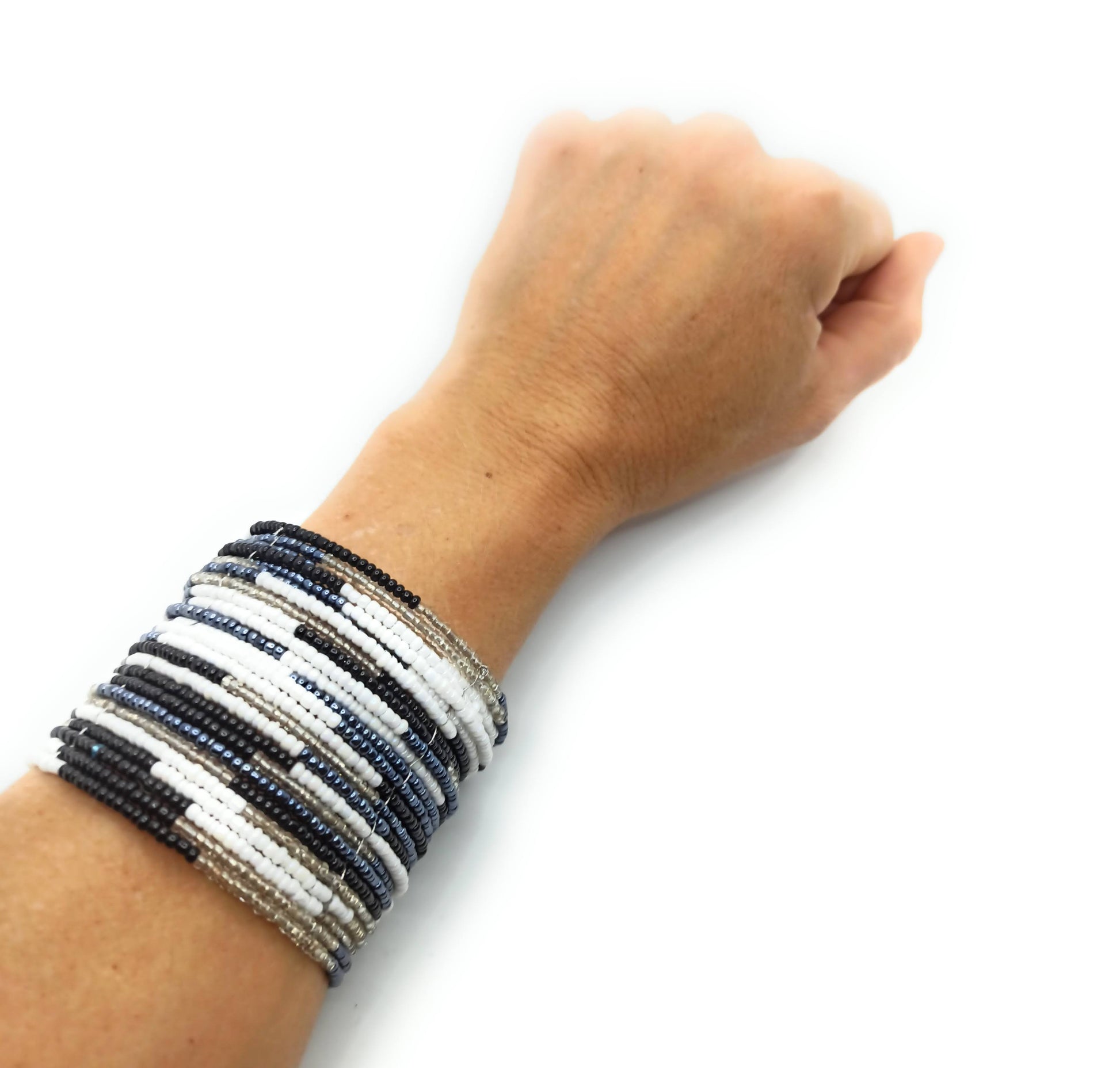 Brazalete artesanal de cuentas en espiral con alambre de metal, hecho a mano con diseño único y colorido.