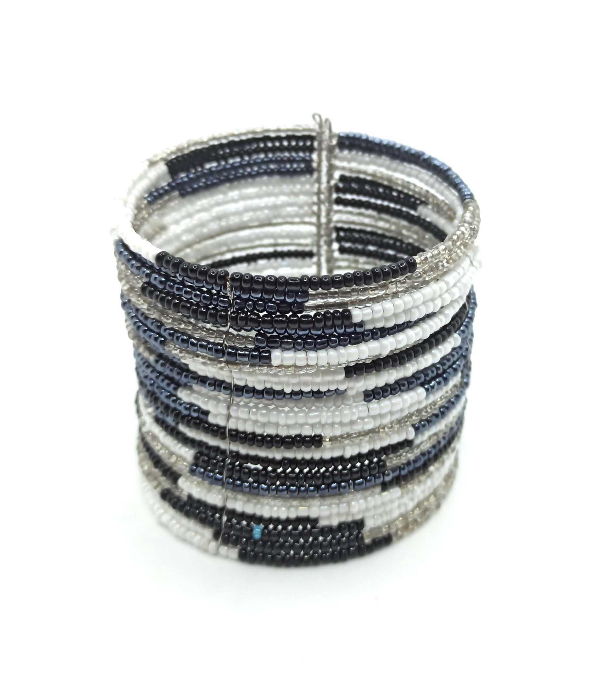 Brazalete artesanal de cuentas en espiral con alambre de metal, hecho a mano con diseño único y colorido.