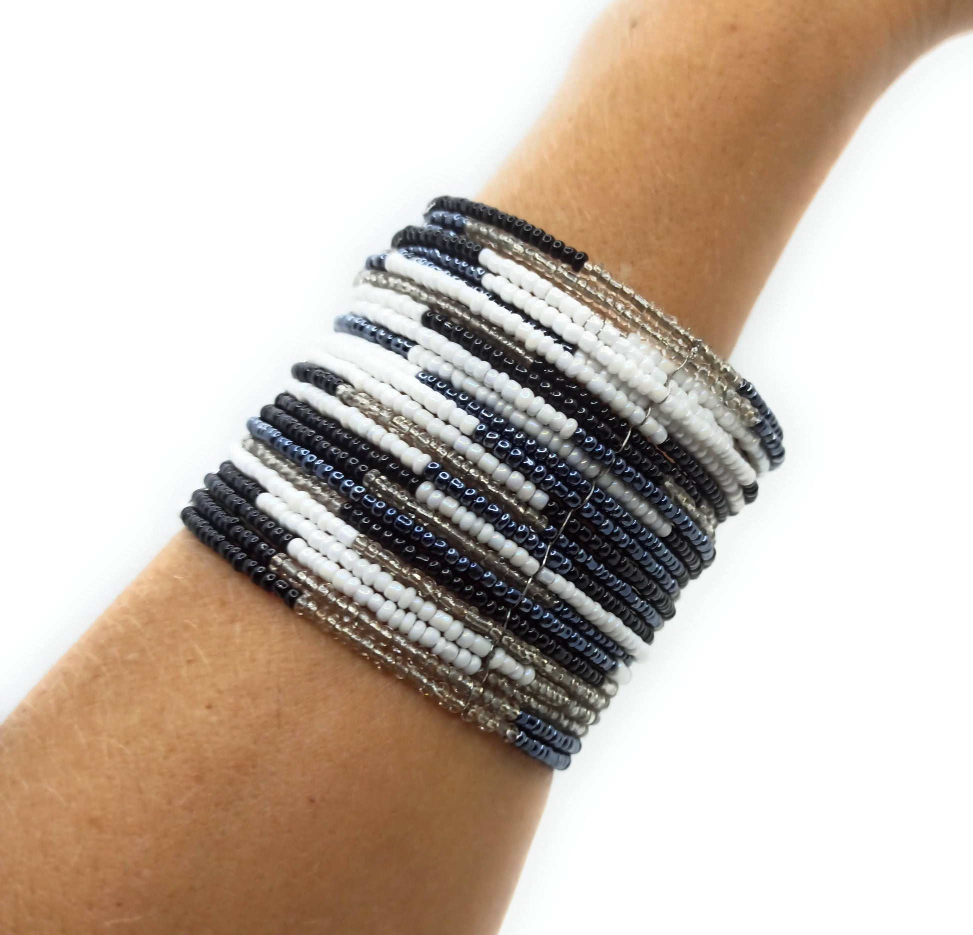 Brazalete artesanal de cuentas en espiral con alambre de metal, hecho a mano con diseño único y colorido.