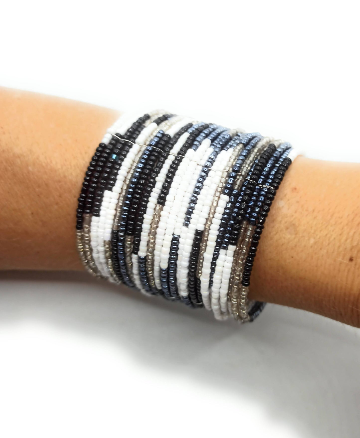 Brazalete artesanal de cuentas en espiral con alambre de metal, hecho a mano con diseño único y colorido.