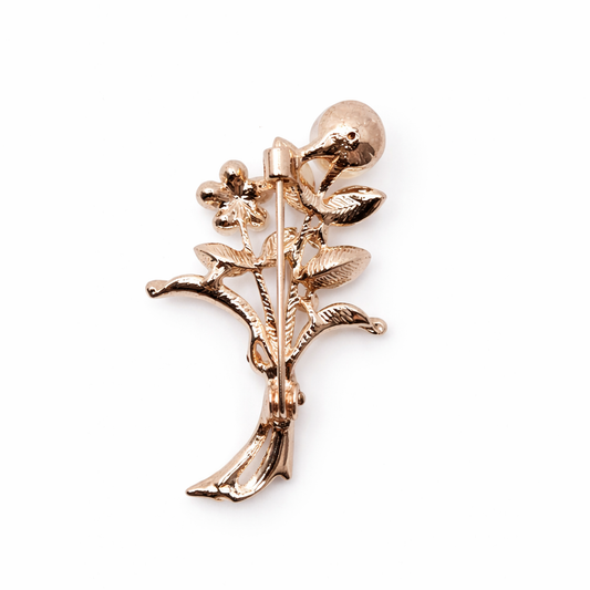 Broche joya floral dorado con detalles en morado, cristales y perla
