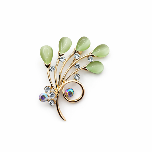 Broche joya floral dorado con detalles en verde y cristales brillantes